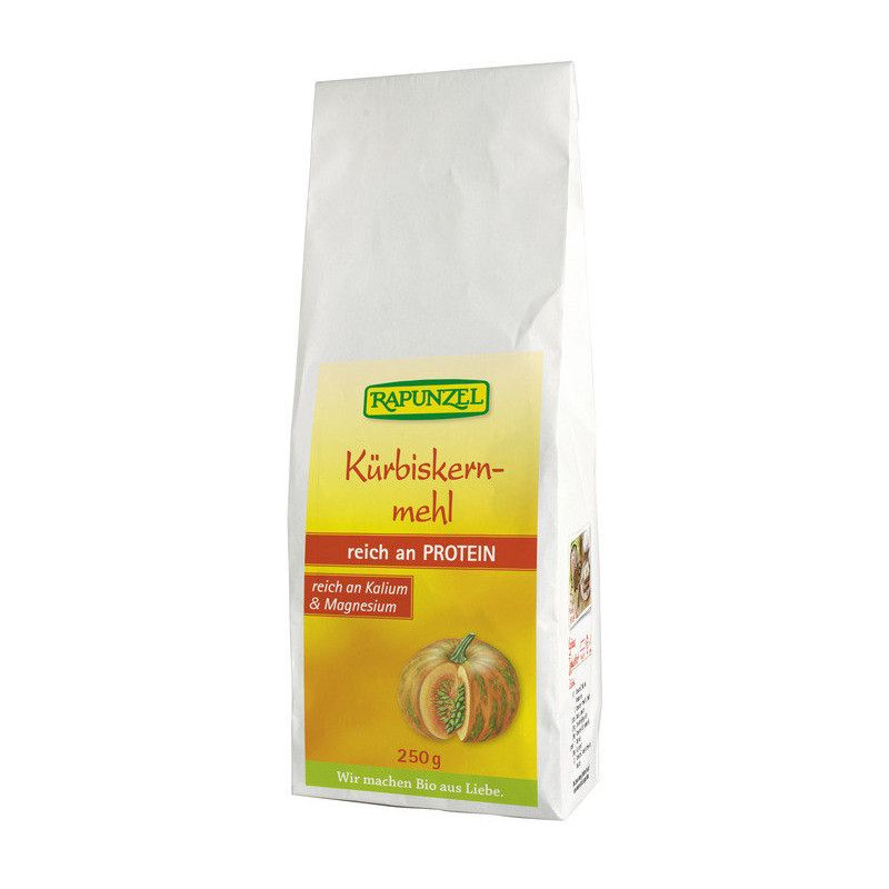 Weißer Beutel mit gelbem Etikett. Aufschrift: RAPUNZEL Kürbiskernmehl, reich an PROTEIN, reich an Kalium & Magnesium. Abbildung einer Kürbis-Hälfte.