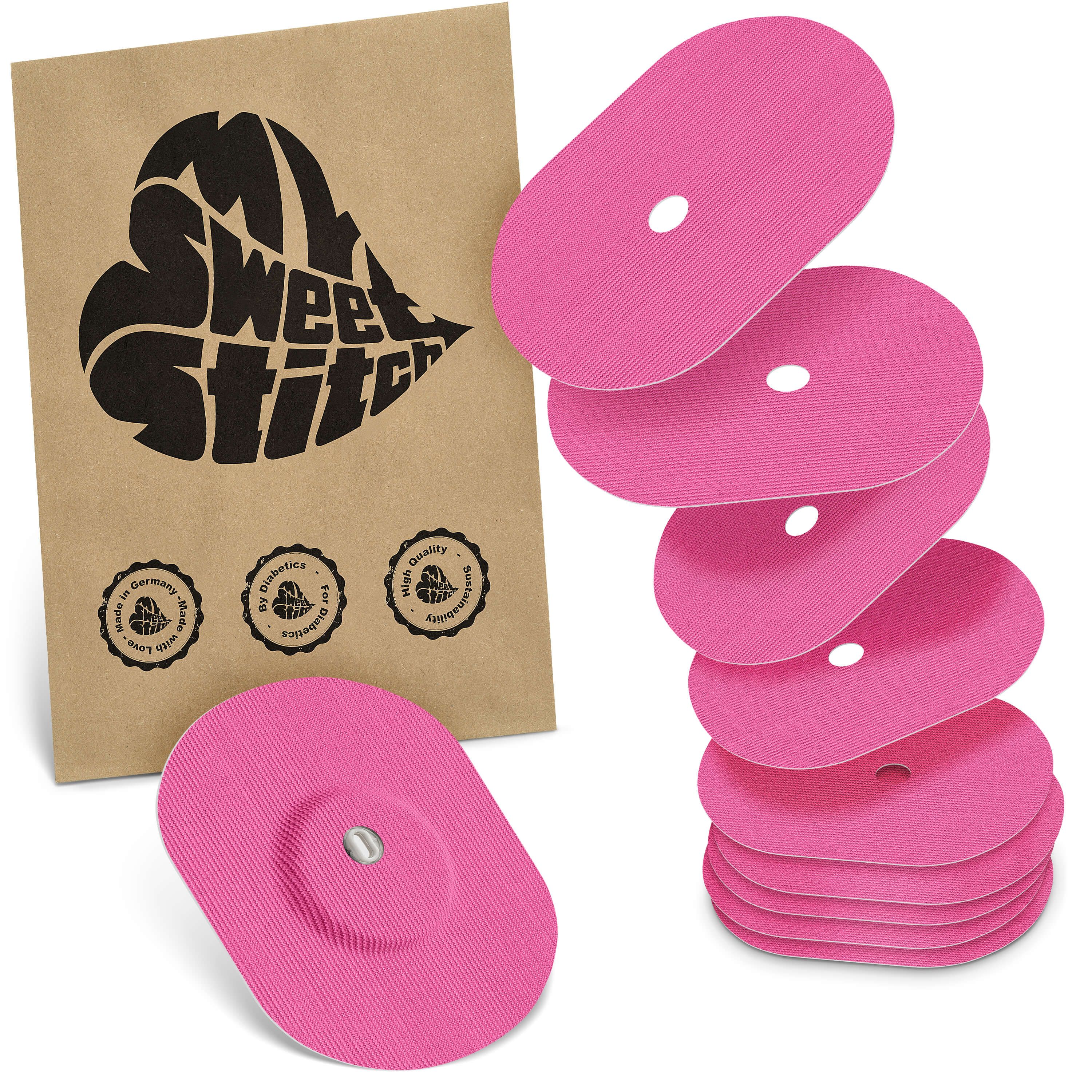 Rosa ovale Pflaster mit Loch, neben brauner Verpackung mit Logo. Mehrere Pflaster gestapelt. Marke: MySweetStitch.