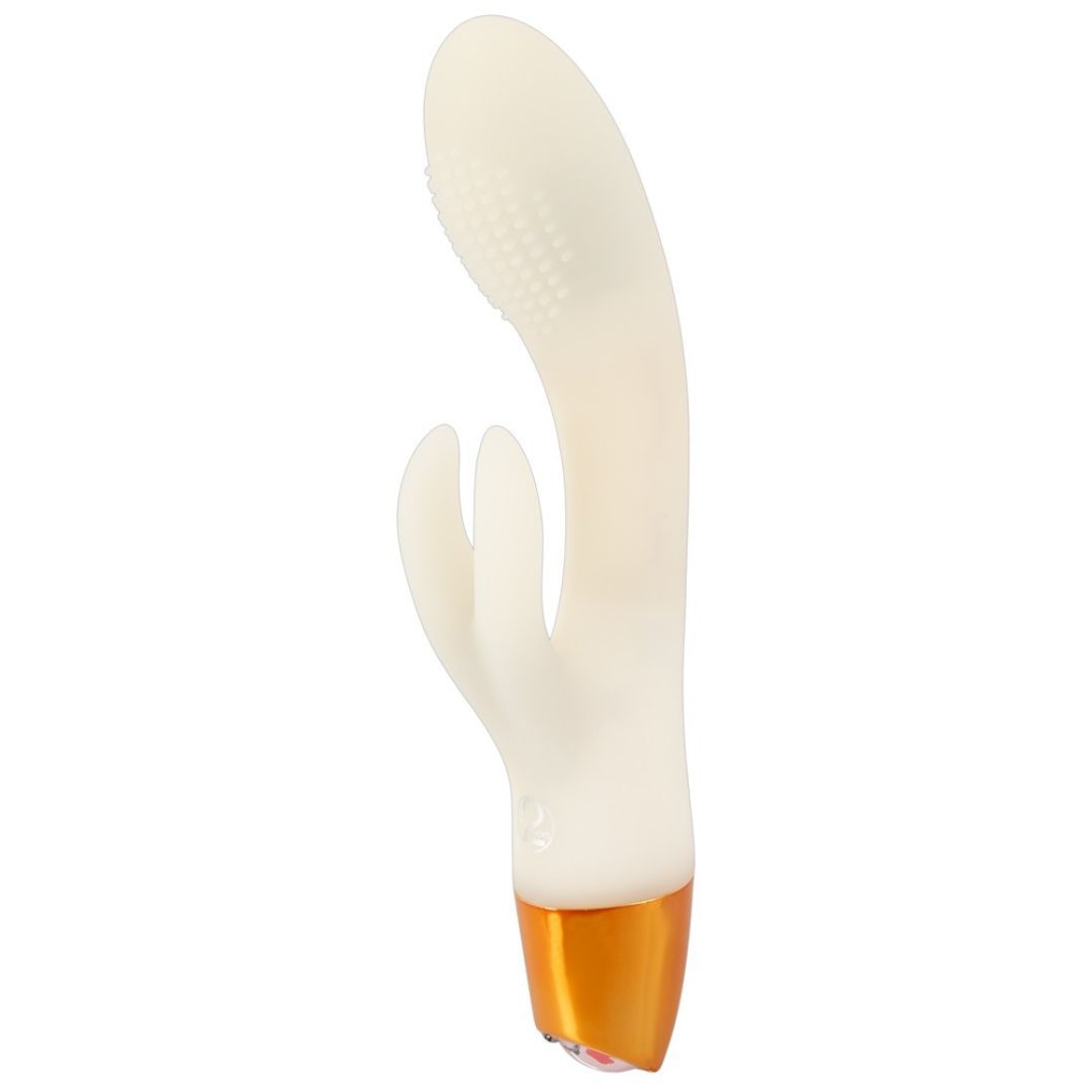 Elfenbeinfarbener Vibrator mit goldfarbenem Sockel. Der Kopf hat eine geriffelte Oberfläche und eine hasenohrförmige Spitze.