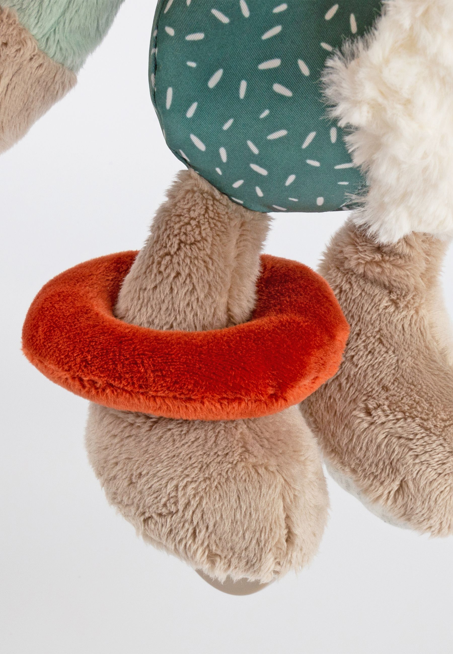 Nahaufnahme des Stoffelefanten mit orangefarbenem Ring und Bein. Der Ring ist um das Bein gelegt.