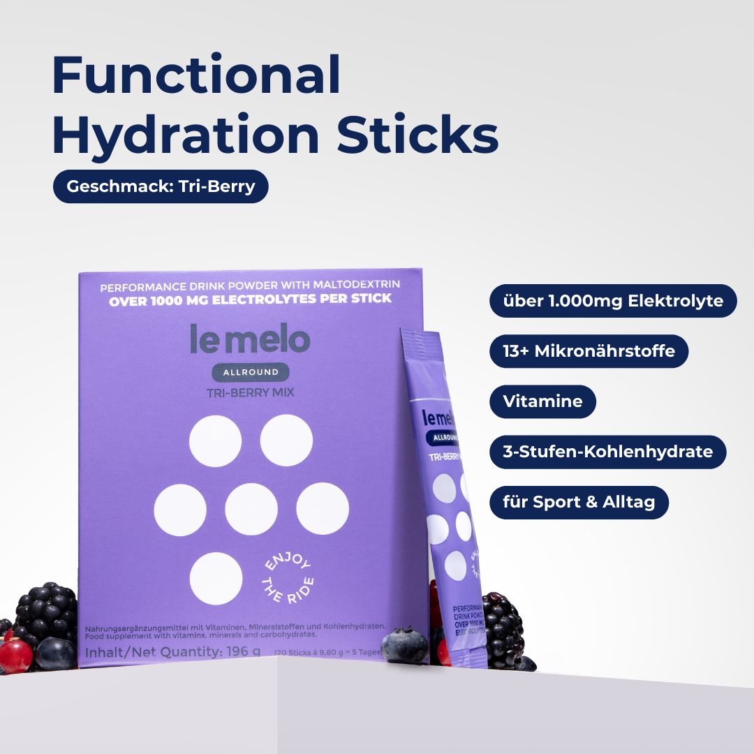 Lila Karton und Stick mit Produktnamen. Text: Functional Hydration Sticks, Geschmack: Tri-Berry. Beerenabbildungen.