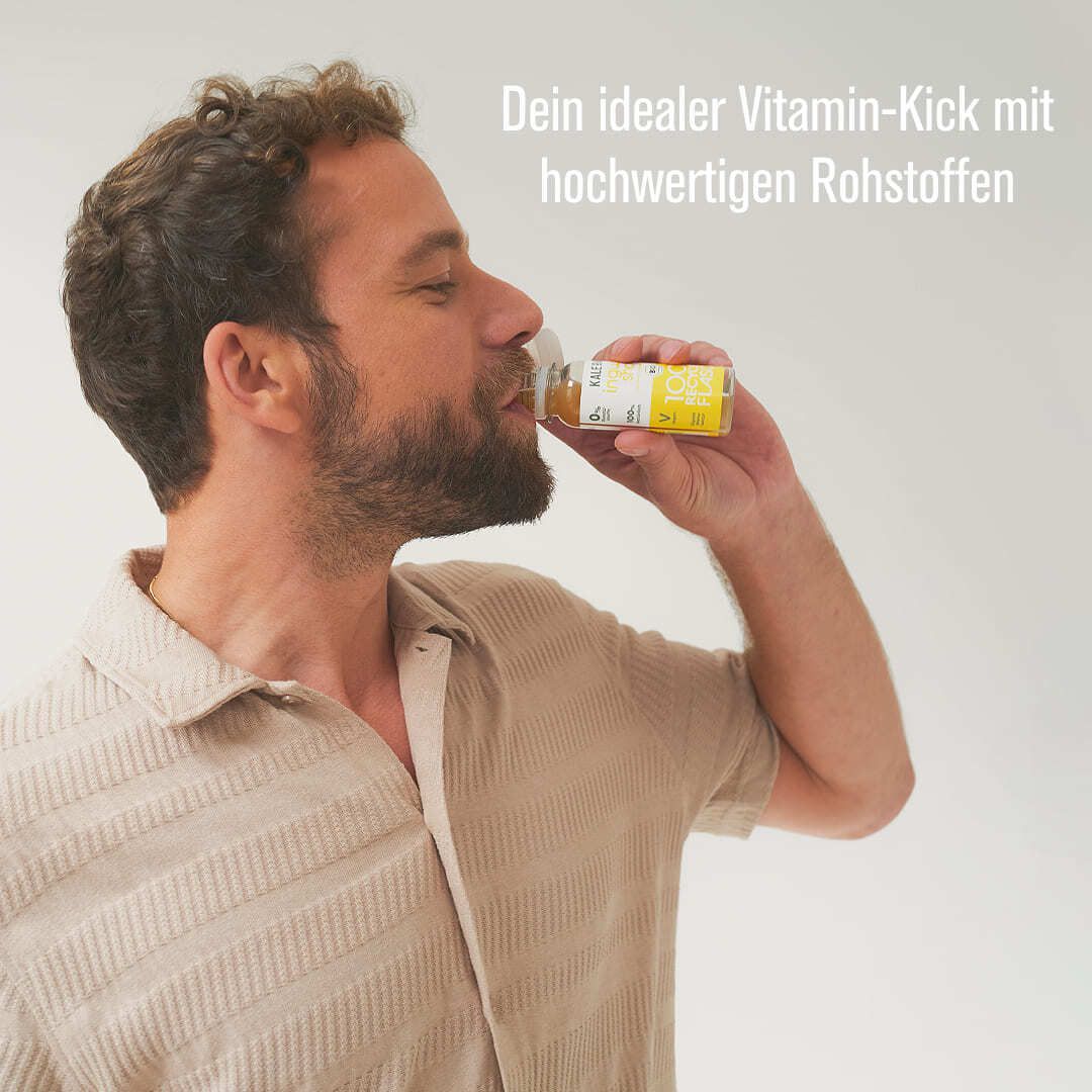 Mann trinkt aus einer kleinen Flasche. Auf der Flasche steht "KALE ME" und der Name des Shots. Text: Dein idealer Vitamin-Kick.