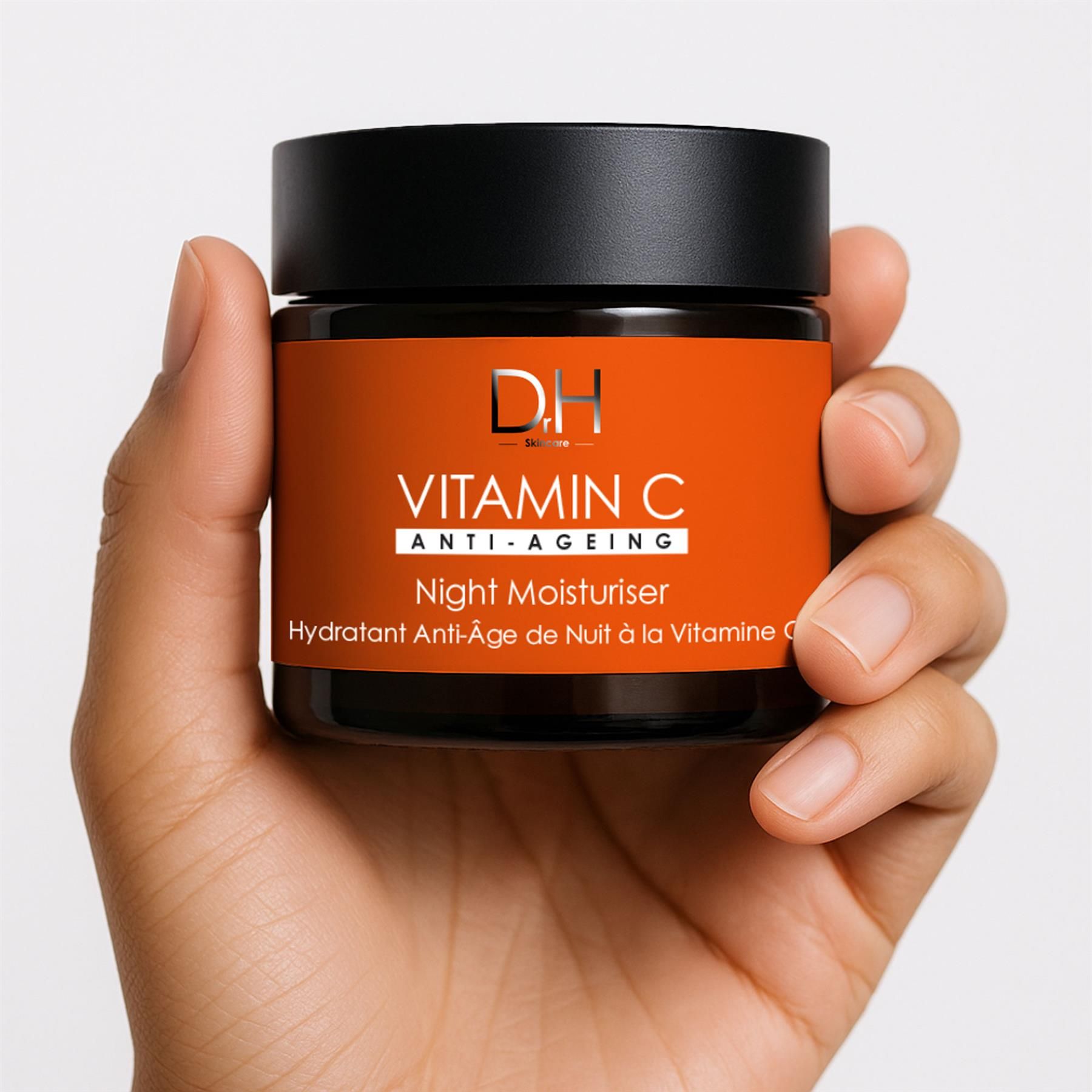 Hand hält ein Glas Dr H Vitamin C Anti-Aging Nachtcreme.
