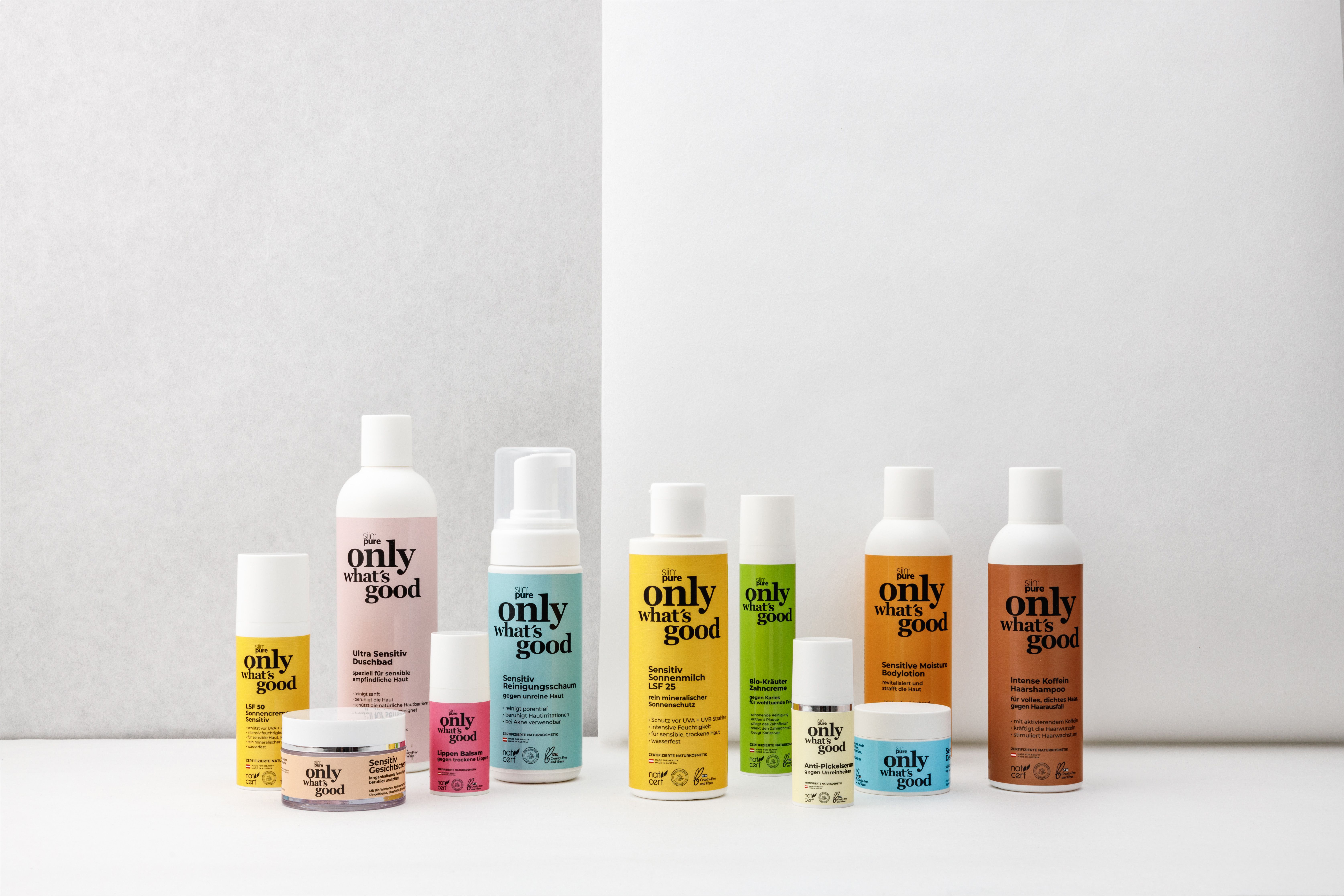 Verschiedene Kosmetikprodukte, darunter Flaschen und Tiegel, mit Etiketten. Aufschrift: only what's good.