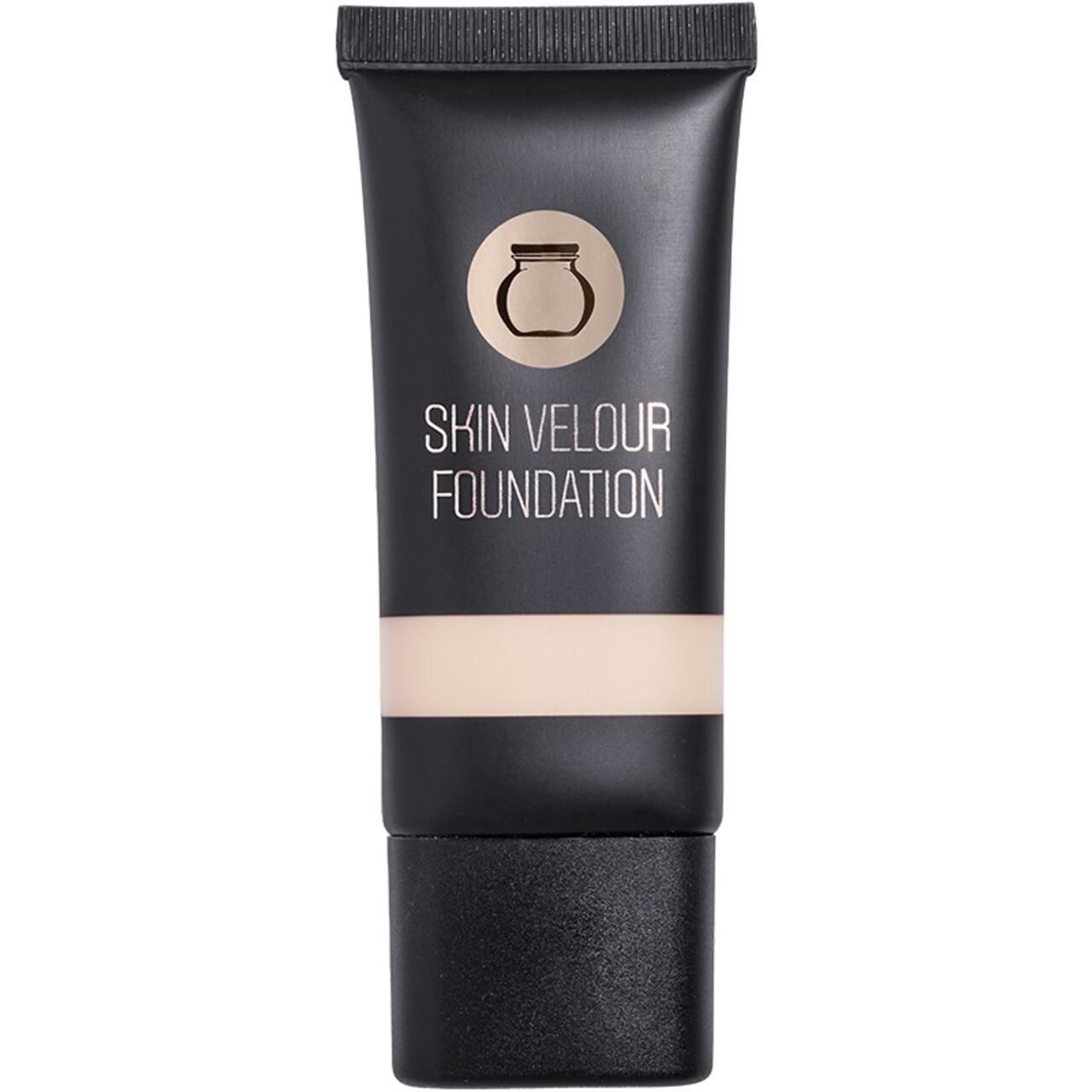 Schwarze Tube mit Aufschrift SKIN VELOUR FOUNDATION. Beige Produkt sichtbar. Oben ein Logo.