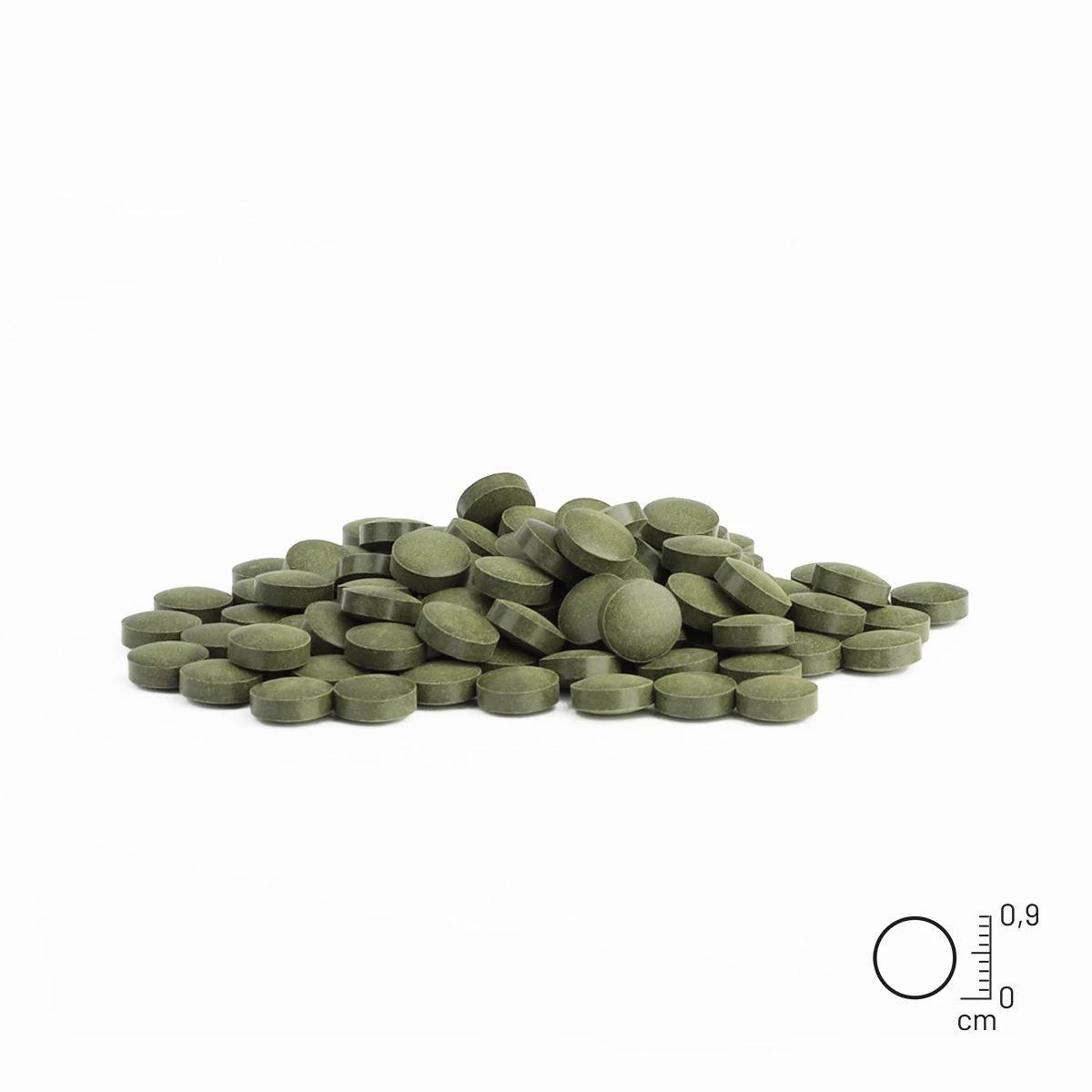 Haufen grüner, runder Tabletten. Daneben eine Skala zur Größenbestimmung.