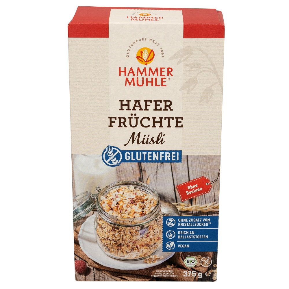 Verpackung von Hafer Früchte Müsli. Aufschrift: Glutenfrei, ohne Zuckerzusatz, reich an Ballaststoffen, vegan. Glas mit Müsli.