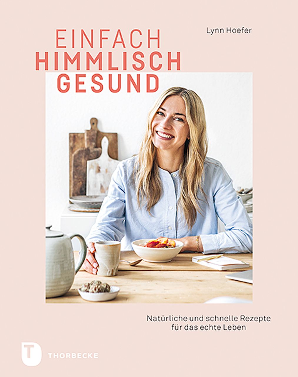 Buchcover mit Titel "Einfach himmlisch gesund". Frau am Tisch mit Essen und Getränken. Autorin: Lynn Hoefer. Verlag: Thorbecke.
