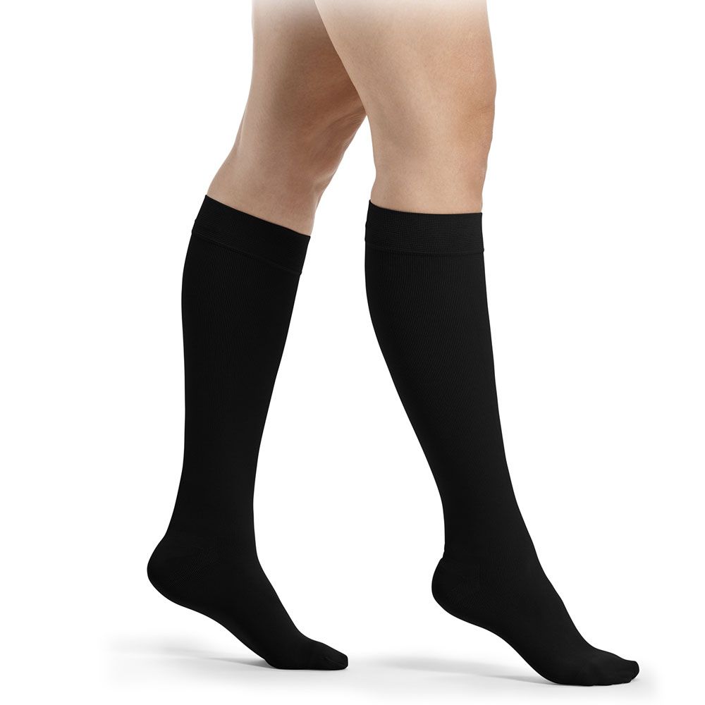 Schwarze Kompressionsstrümpfe bis zum Knie.