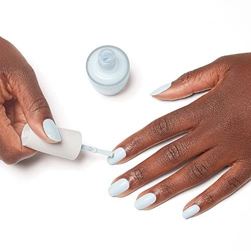 Hände lackieren Nägel hellblau. Nagellackflasche und Pinsel. Maniküre-Prozess.