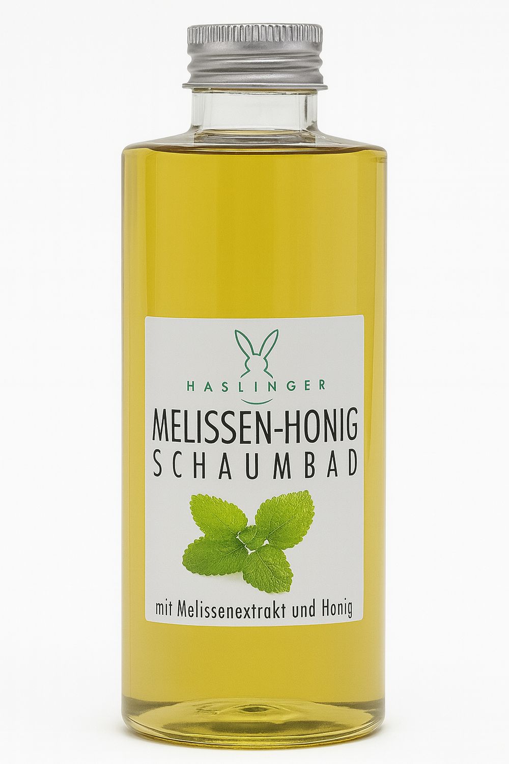 Glasflasche mit gelber Flüssigkeit. Etikett mit Logo, Schriftzug „Melissen-Honig Schaumbad“ und Kräuterabbildung. Silberner Schraubverschluss.
