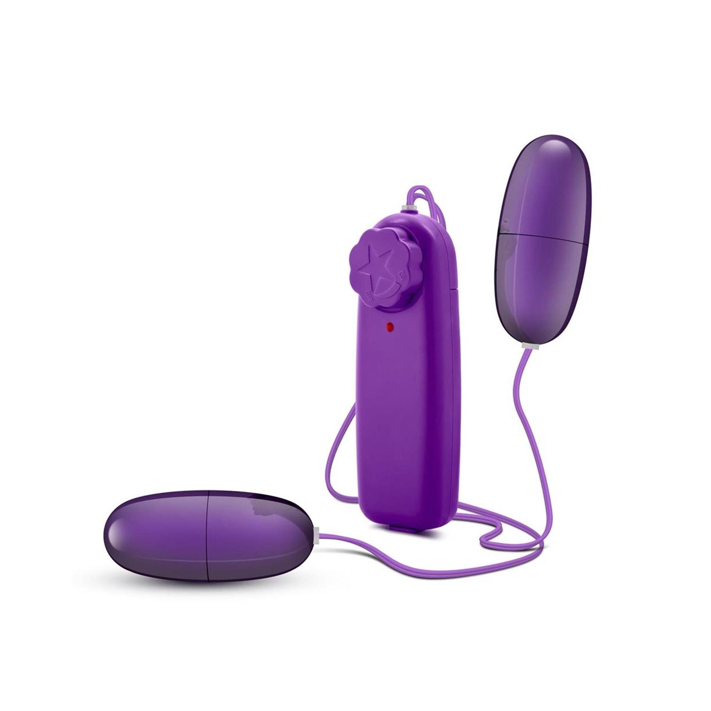 Lila Doppel-Ei-Vibrator mit Fernbedienung. Zwei Eier und eine Fernbedienung mit Sternmuster. Kabel verbinden die Teile.