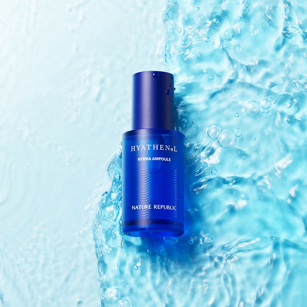 Blaue Serumflasche im Wasser. Schriftzug HYATHENOL, Hydra Ampoule und NATURE REPUBLIC. Wasser im Hintergrund.