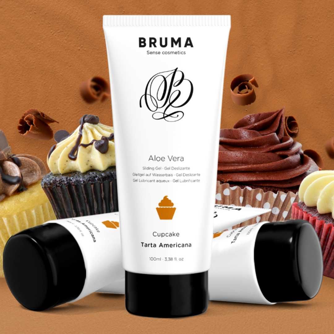 Drei weiße Tuben mit schwarzem Deckel. Aufschrift BRUMA, Aloe Vera, Cupcake, Tarta Americana. Cupcakes im Hintergrund.