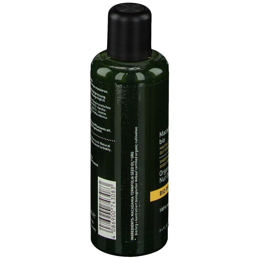 Grüne Flasche mit schwarzem Deckel. Etikett mit Text und Barcode. Aufschrift: Macadamia BIO. Zutatenliste.