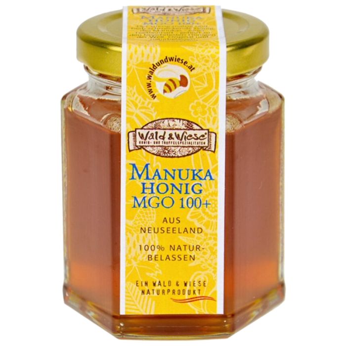 Glas Honig mit gelbem Etikett. Aufschrift: Manuka Honig MGO 100+ aus Neuseeland. 100% naturbelassen. Marke: Wald & Wiese.