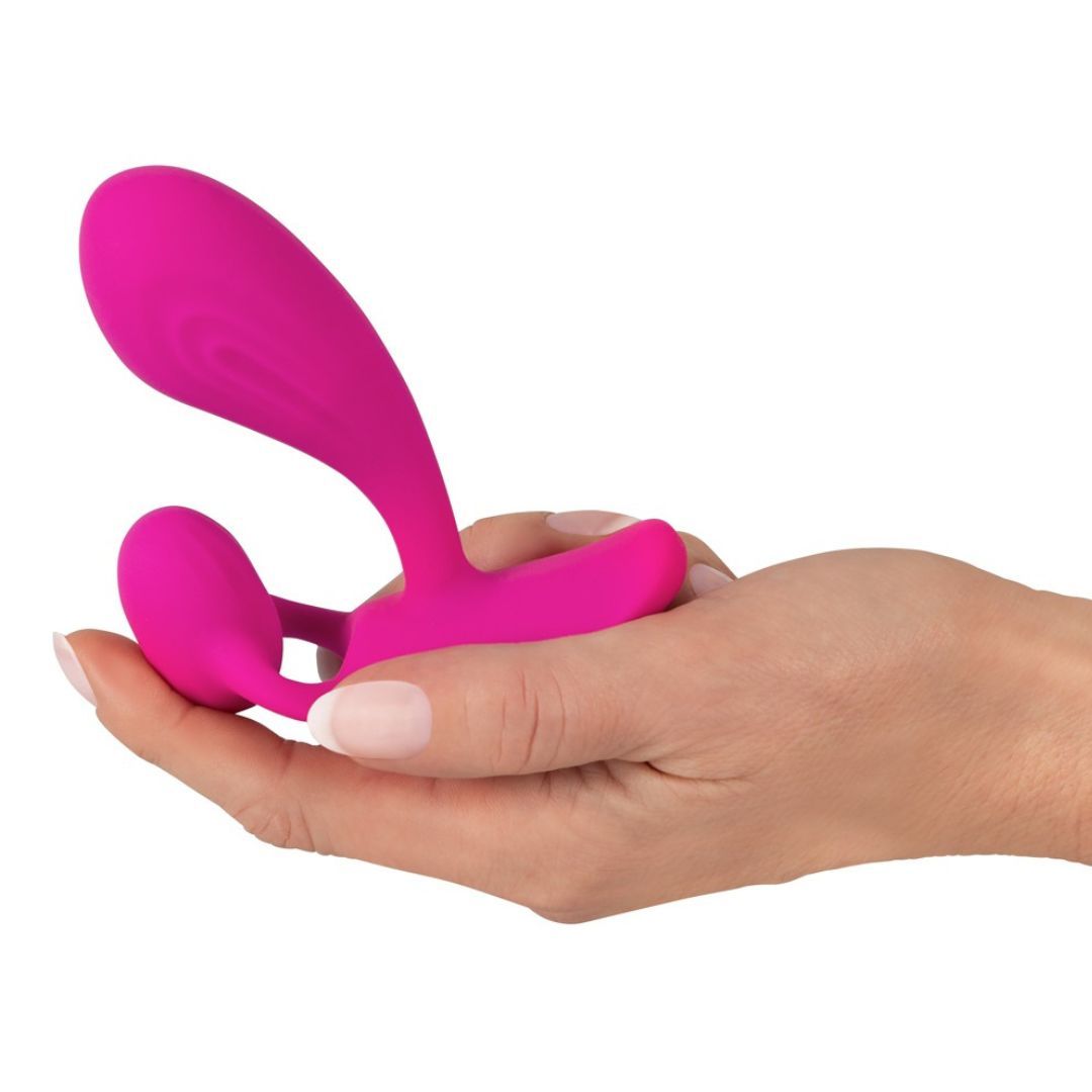 Pinkfarbener Vibrator in einer Hand gehalten. Der Vibrator hat eine geschwungene Form mit zwei Enden.