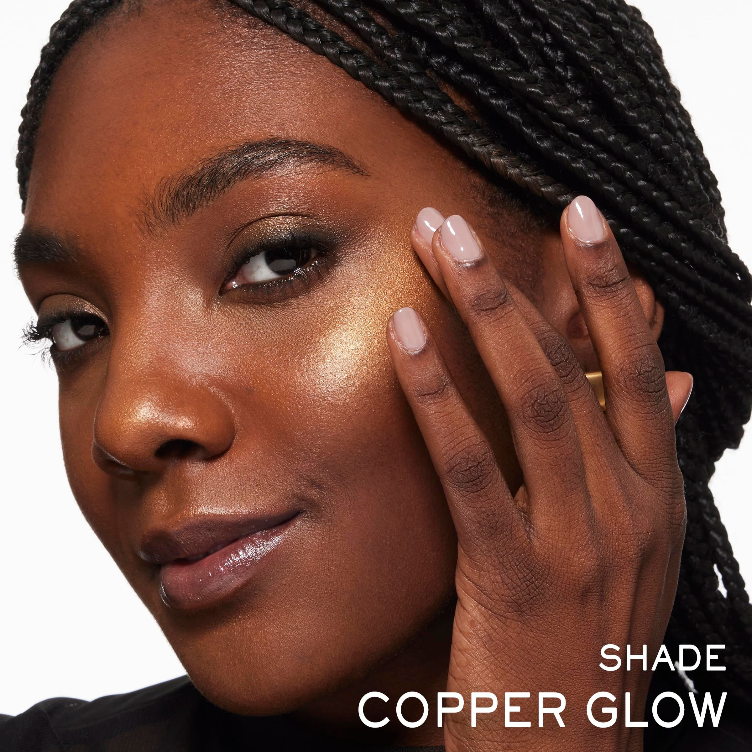 Porträt einer Frau mit dunkler Haut. Aufgetragenes Produkt im Gesicht. Text: COPPER GLOW.