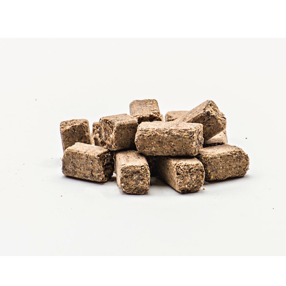 Haufen brauner, quaderförmiger Leckerlis auf weißem Hintergrund. Die Leckerlis sind unregelmäßig geformt.