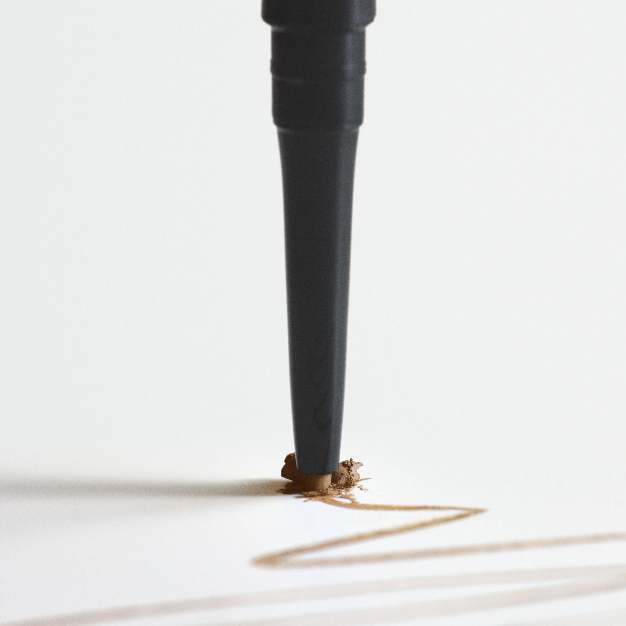 Spitze des RevitaLash Hi-Def Brow Pencil in Soft Brown, die eine Linie zieht.