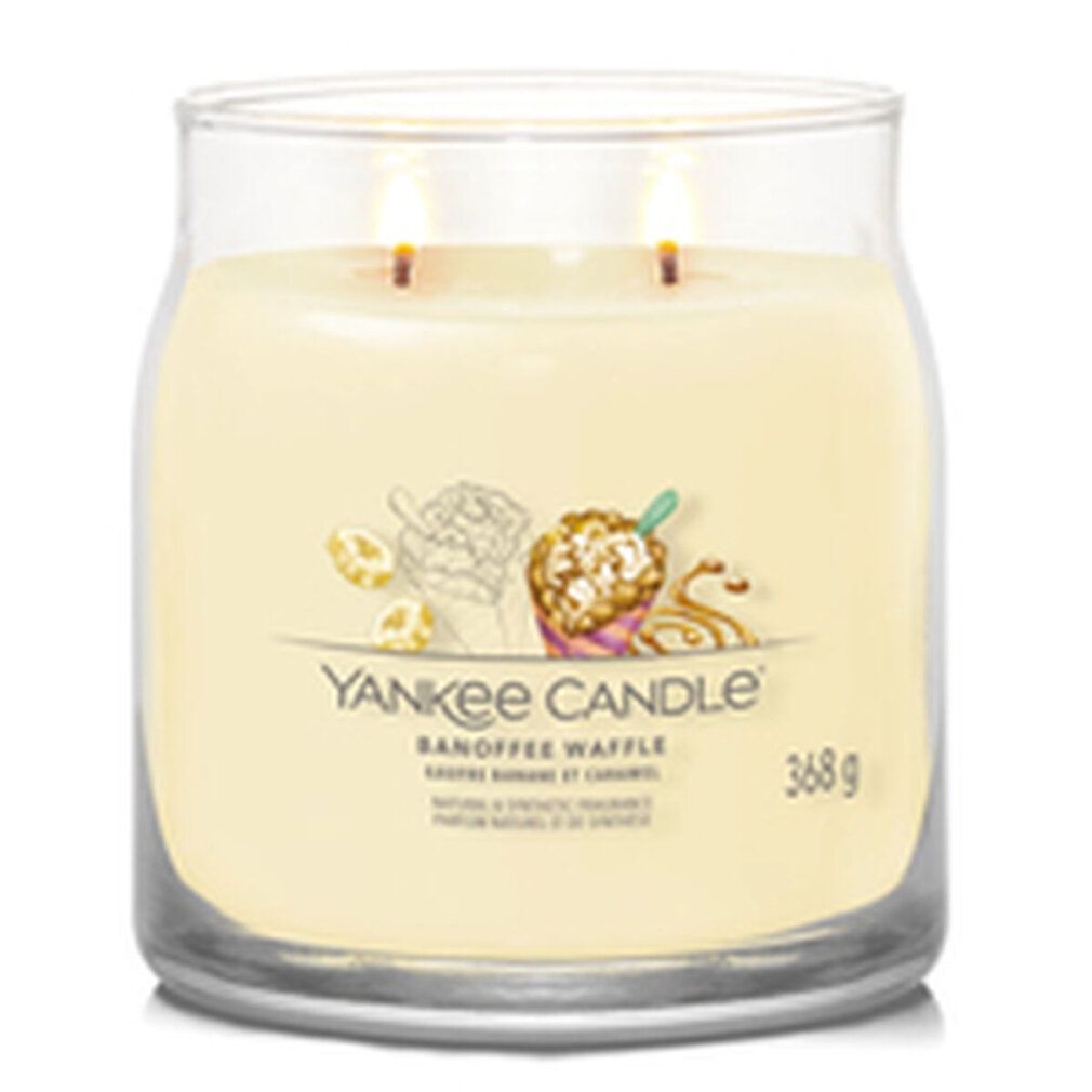 Glas-Duftkerze mit zwei Dochten. Aufkleber mit Illustrationen und Schriftzug "Yankee Candle Banoffee Waffle". Gewicht: 368 g.