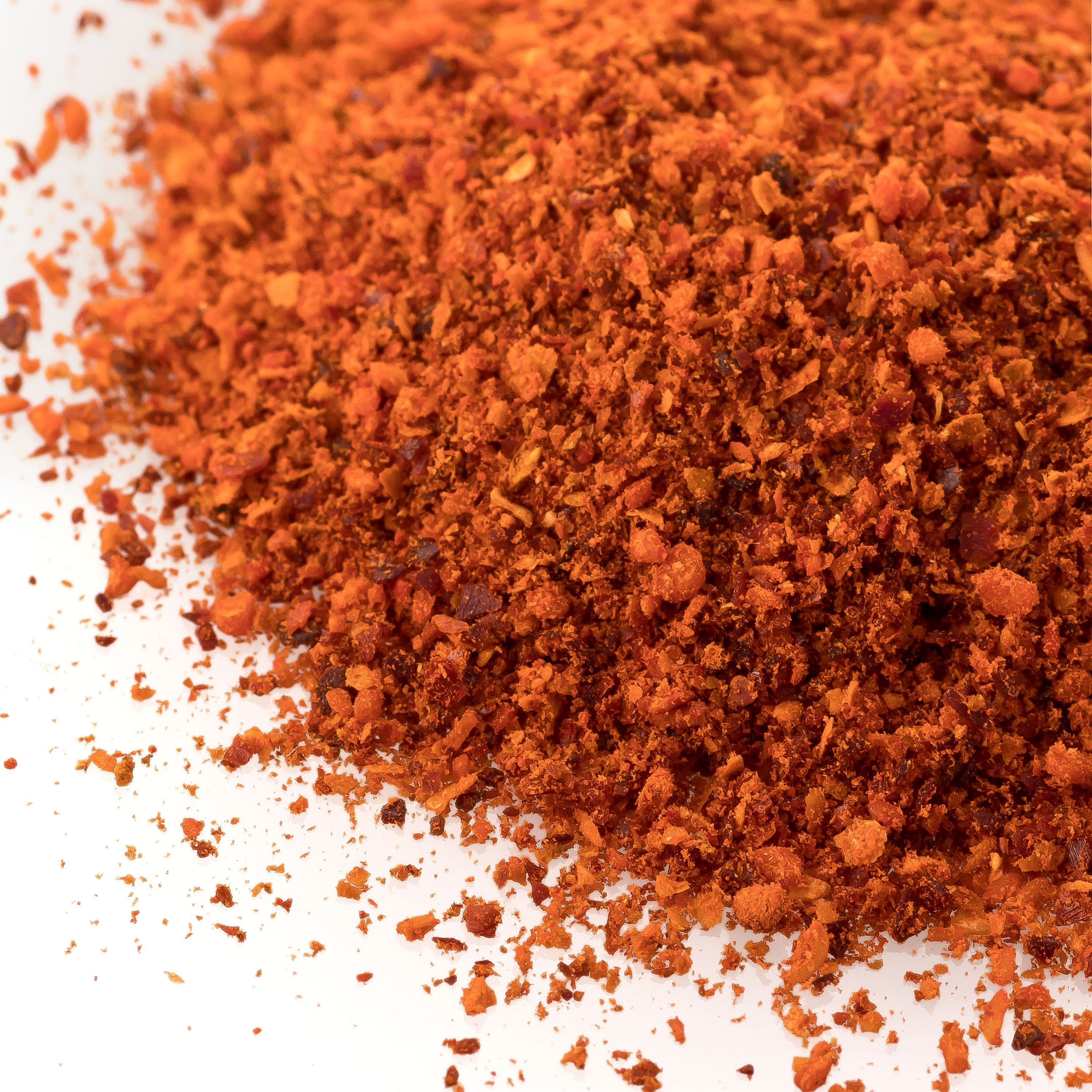 Haufen von rotem Chili-Pulver. Nahaufnahme, feine Textur. Weißer Hintergrund.