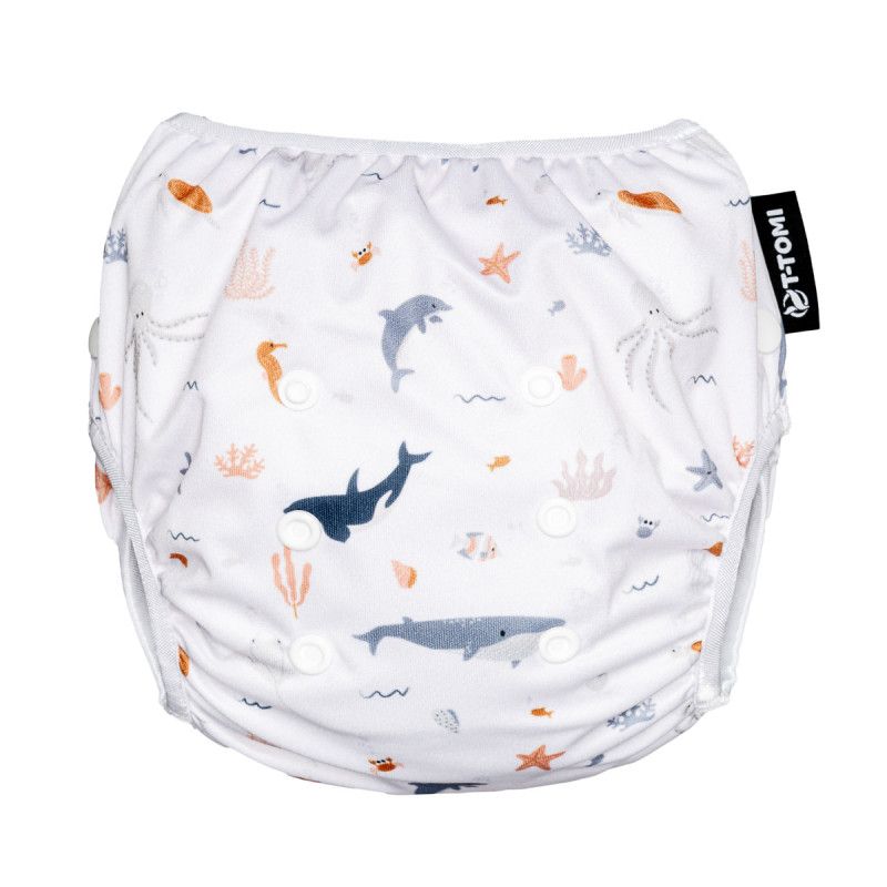 Weiße Schwimmwindel mit Meeresmotiven. Mit Druckknöpfen und T-TOMI-Logo. Bedruckt mit Fischen, Walen und Seepferdchen.