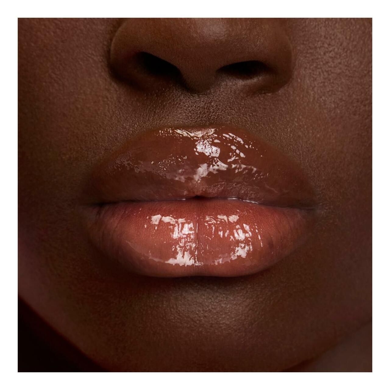 Nahaufnahme von Lippen. Glänzender, rosafarbener Lippenstift. Hautton dunkel. Lippen glänzend.