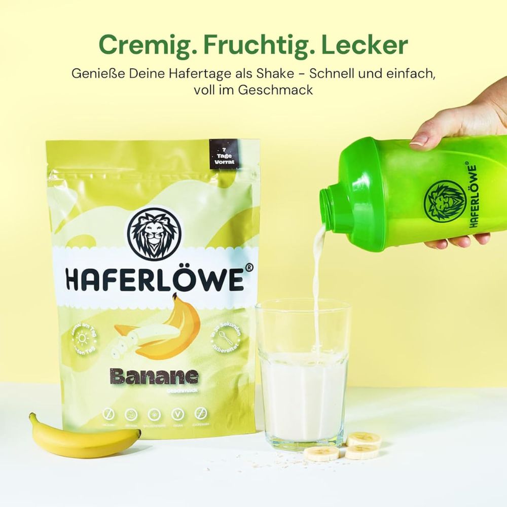 Eine Hand gießt Shake aus einem grünen Shaker in ein Glas. Daneben eine Tüte HAFERLÖWE Banane und Bananenscheiben.