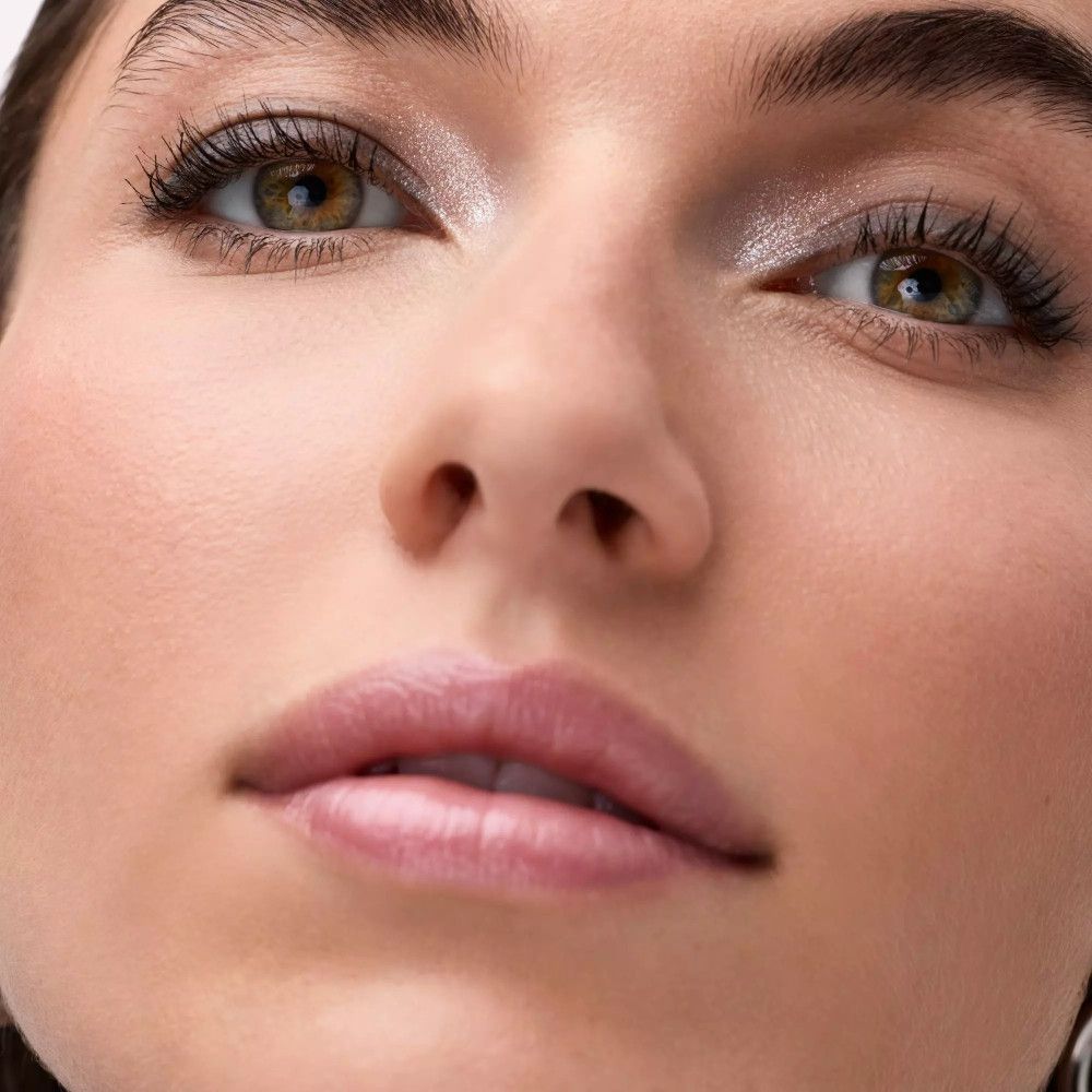 Nahaufnahme eines geschminkten Auges. Lidschatten sichtbar. Hautton hell.