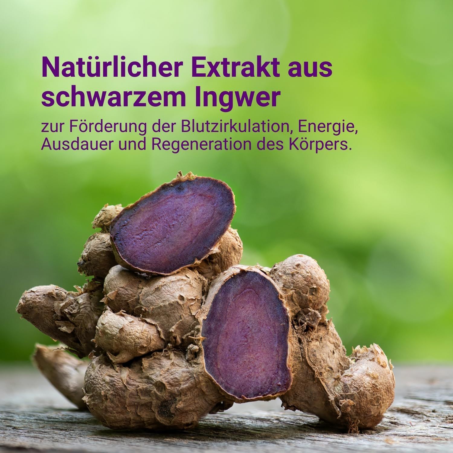 Zwei Hälften einer schwarzen Ingwerknolle. Schnittfläche violett. Auf Holzuntergrund. Hintergrund: grüner Farbverlauf.