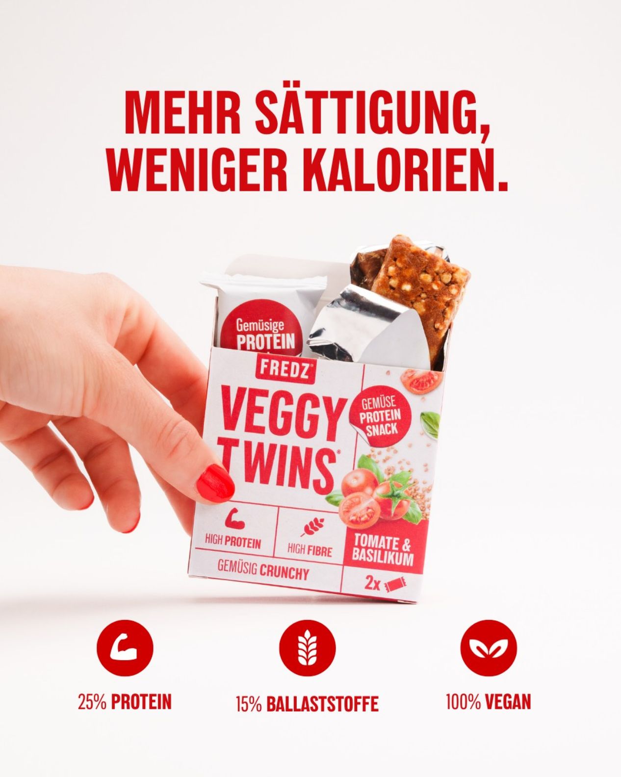 Hand hält eine Packung FREDZ VeggyTwins® - Gemüsiger Proteinsnack. Aufschrift: Tomate & Basilikum. Rote Nägel. Icons: 25% Protein, 15% Ballaststoffe, 100% vegan.