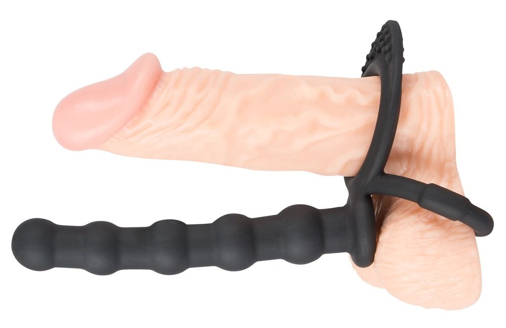 Penis mit schwarzem Penis-/Hodenring und Analdildo. Ring mit Noppen, Dildo geriffelt. Aus Silikon.