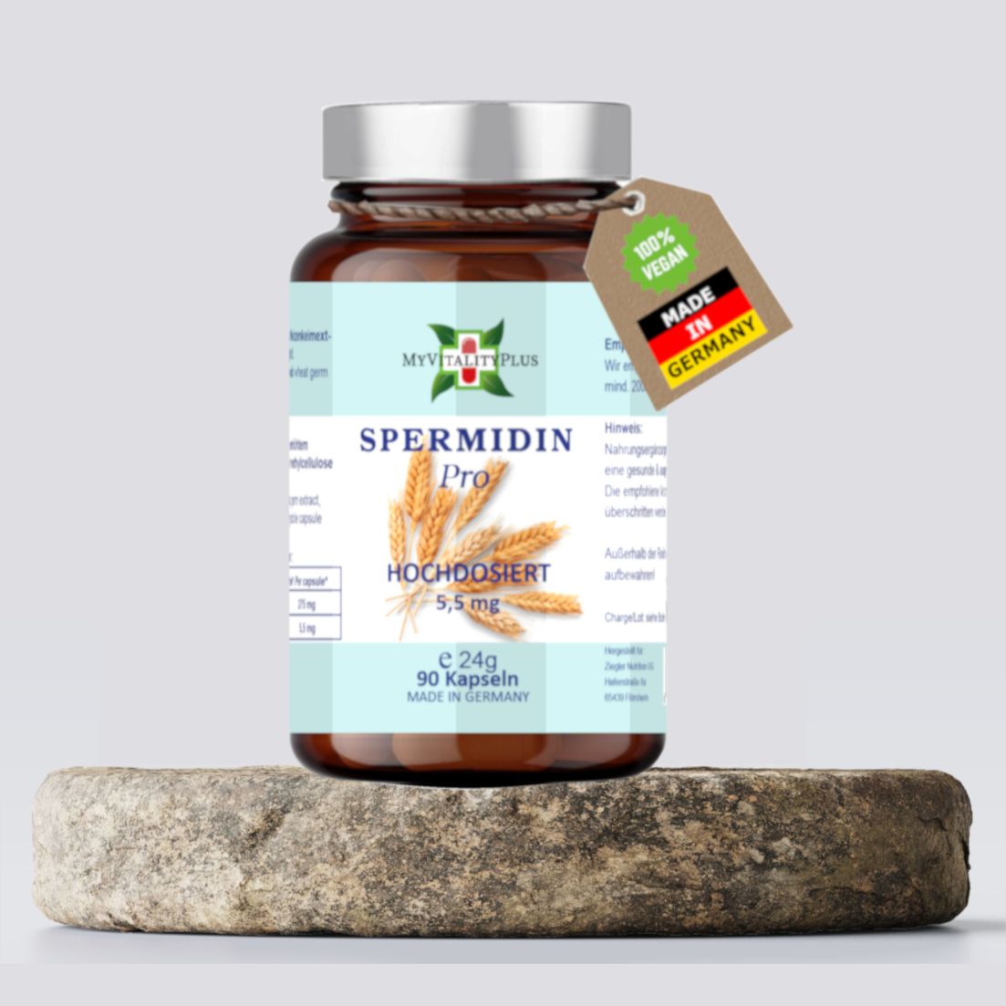 Braune Glasflasche mit silbernem Deckel. Etikett mit Produktnamen Spermidin Pro, Logo MyVitalityPlus. Anhänger "100% Vegan" und "Made in Germany". Auf Stein.