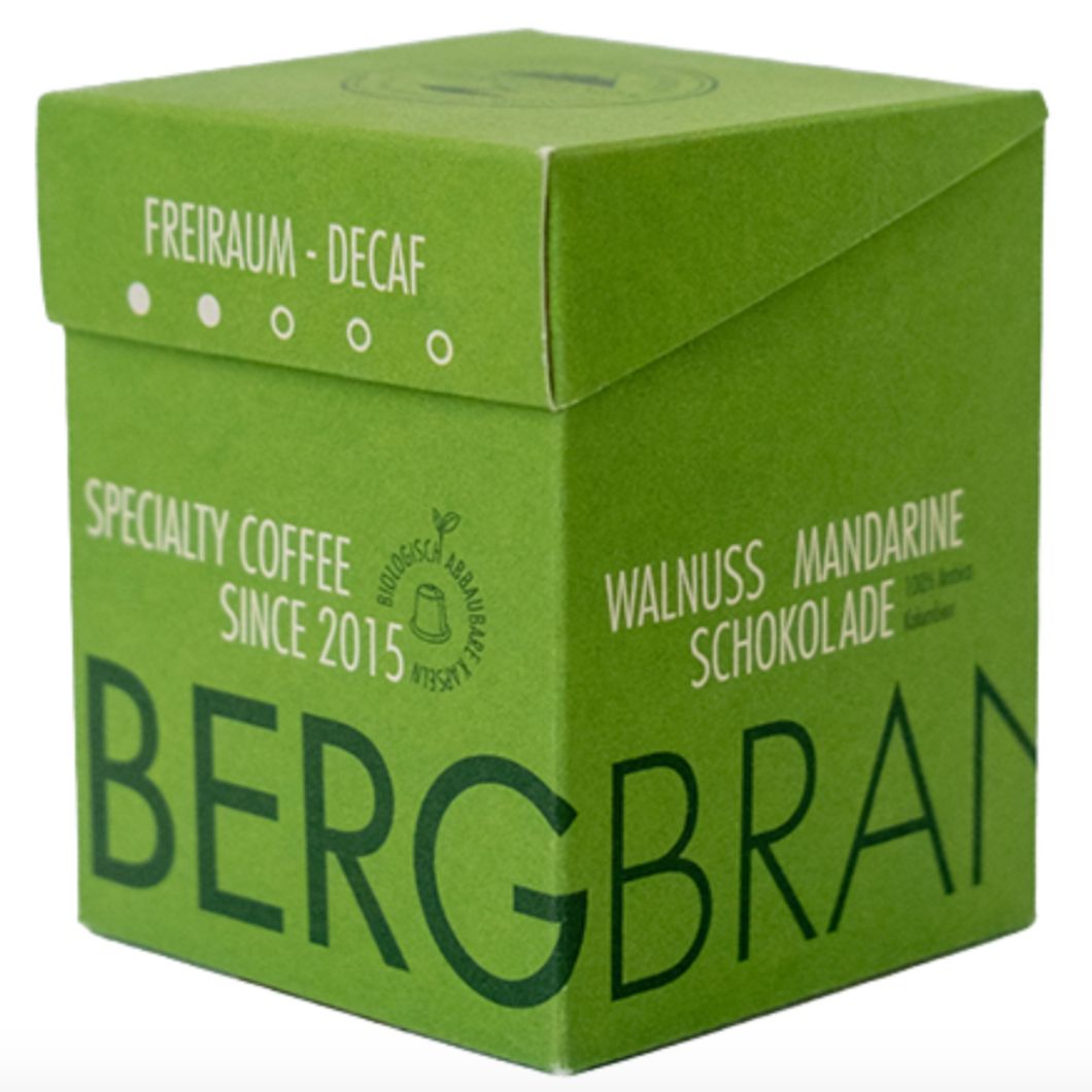 Grüne Verpackung. Aufschrift: BERGBRAND, Freiraum-Decaf, Walnuss Mandarine Schokolade.