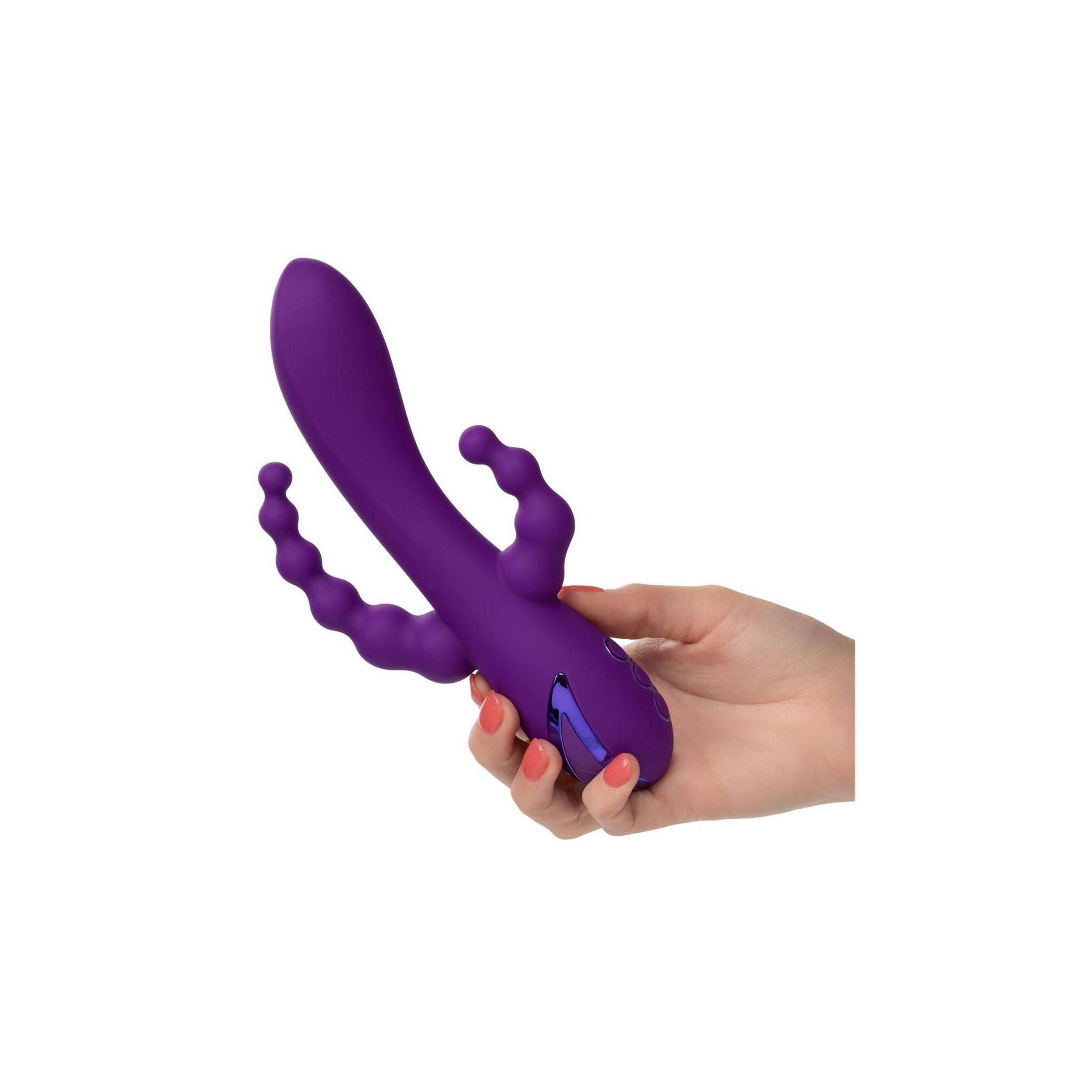 Eine Hand hält einen lila Vibrator. Der Vibrator hat drei Knöpfe und wellenförmige Elemente.