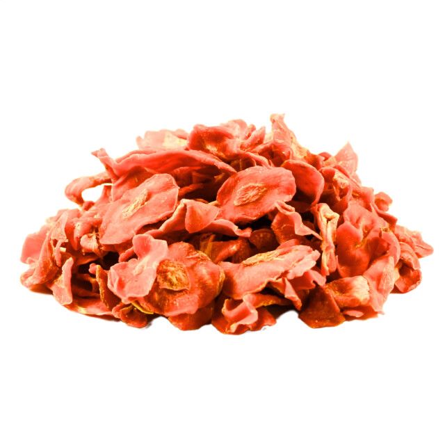 Getrocknete Karottenstücke, orange-rot, auf weißem Hintergrund. Einzelne Stücke mit sichtbaren Kernen.