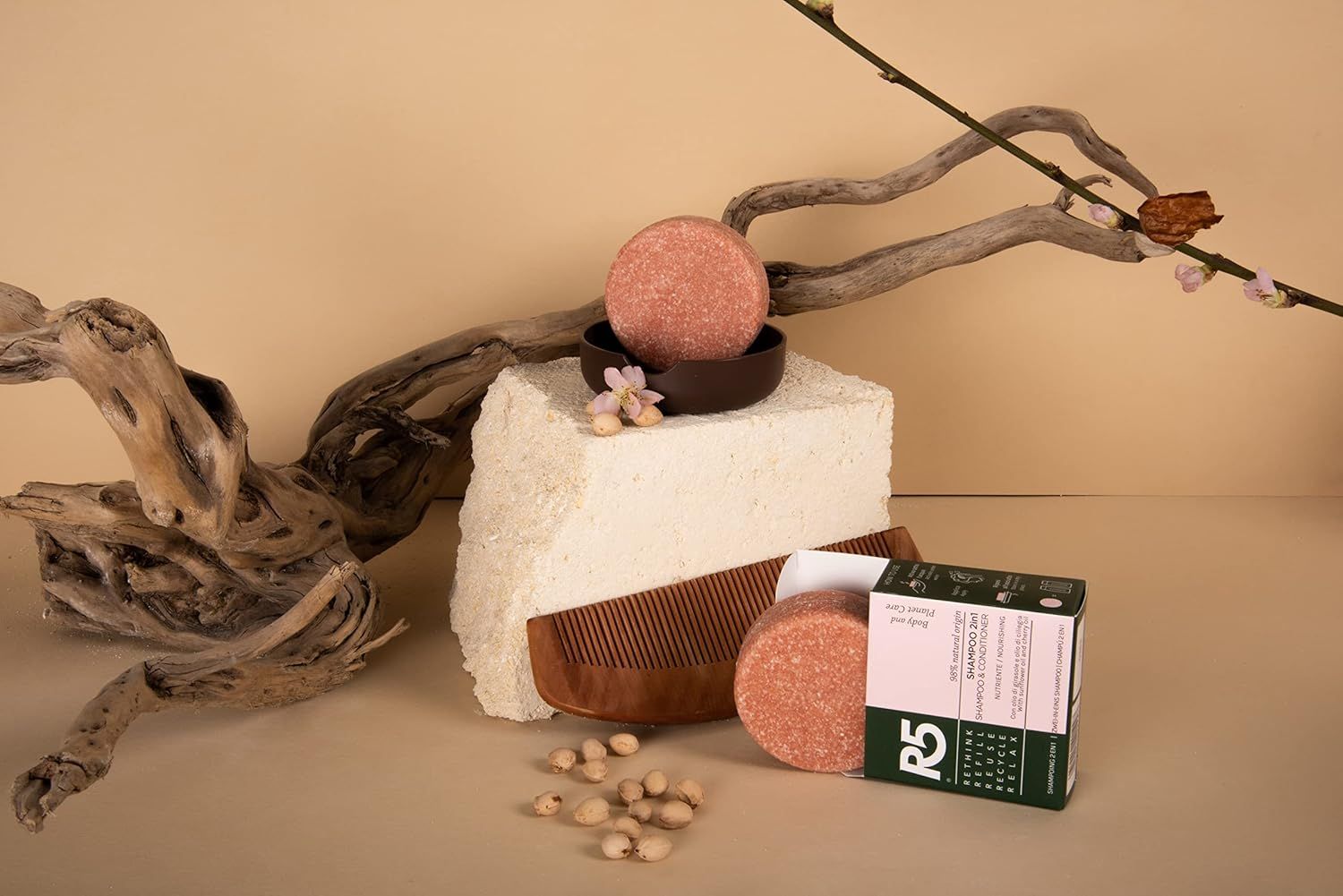 Rundes, rosafarbenes Shampoo auf einem Sockel. Zubehör: Kamm, Verpackung. Text auf der Verpackung. R5-Logo.