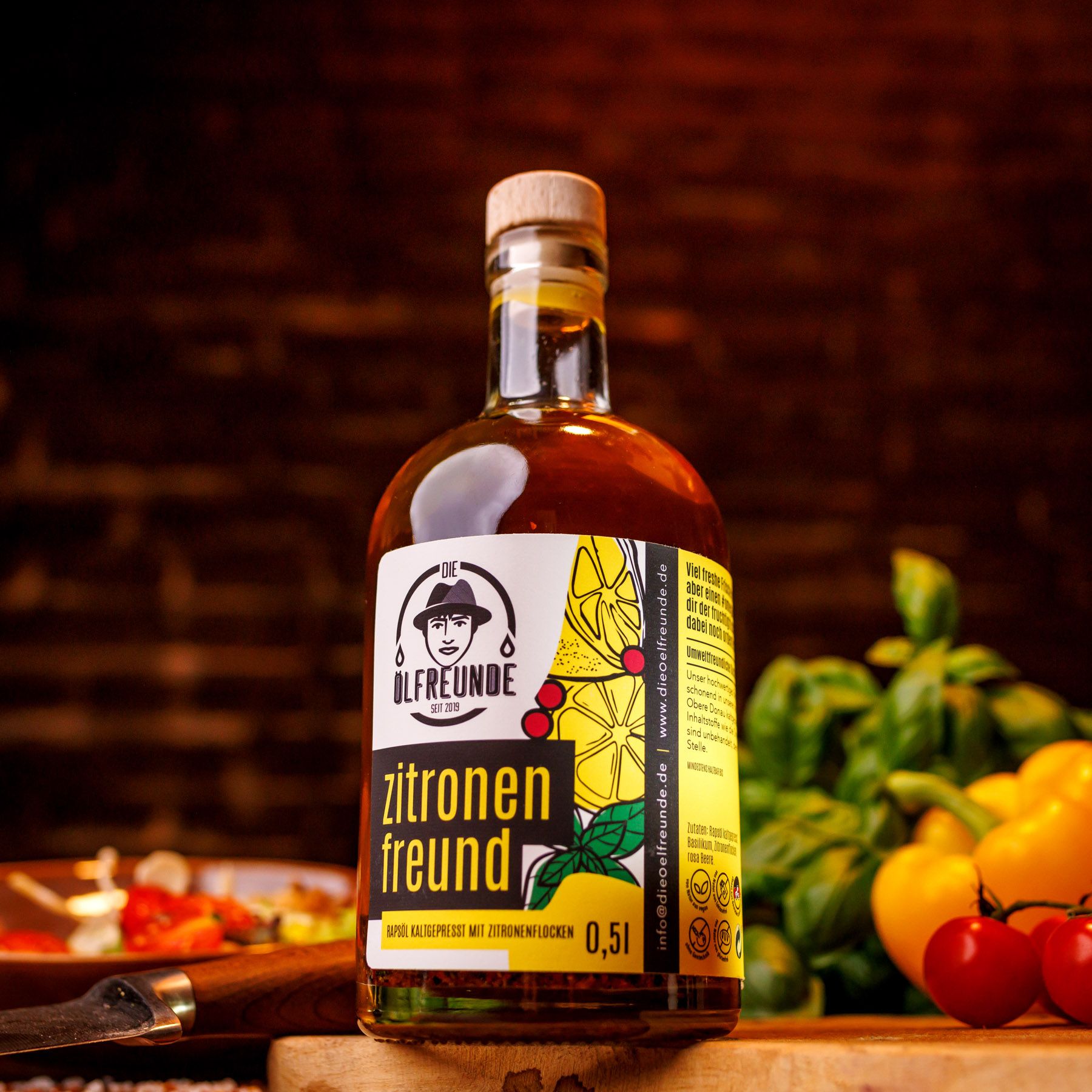 Glasflasche mit Korken, gefüllt mit Flüssigkeit und Kräutern. Etikett mit Produktname und Logo. Auf Holzbrett.