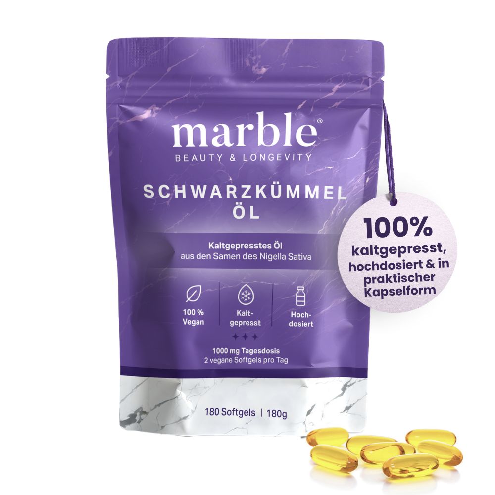 Produktverpackung mit Softgels. Text: marble, Schwarzkümmel Öl, 180 Softgels. 100% kaltgepresst. Einige Softgels liegen daneben.