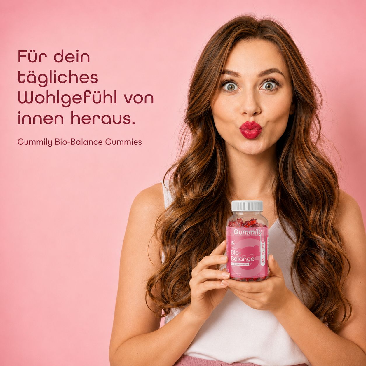 Frau hält Gummily Bio-Balance Gummibärchen Flasche, für tägliches Wohlgefühl.