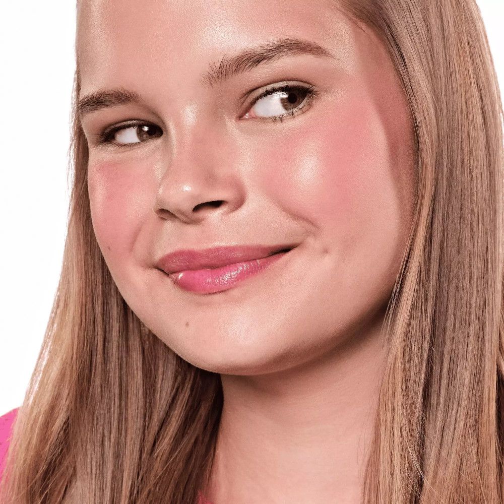 Porträt eines Mädchens mit Rouge auf den Wangen. Rosa Lippen. Blondes Haar.