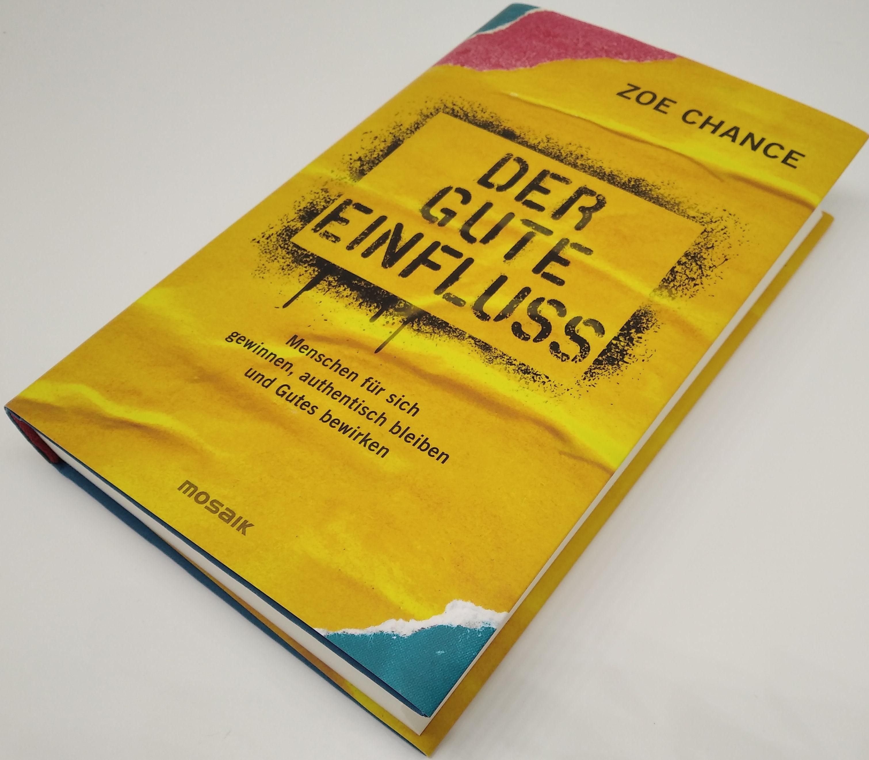 Buch "Der gute Einfluss" mit gelbem Cover. Titel und Autor sichtbar. Buch liegt leicht schräg. Mosaik-Logo unten.