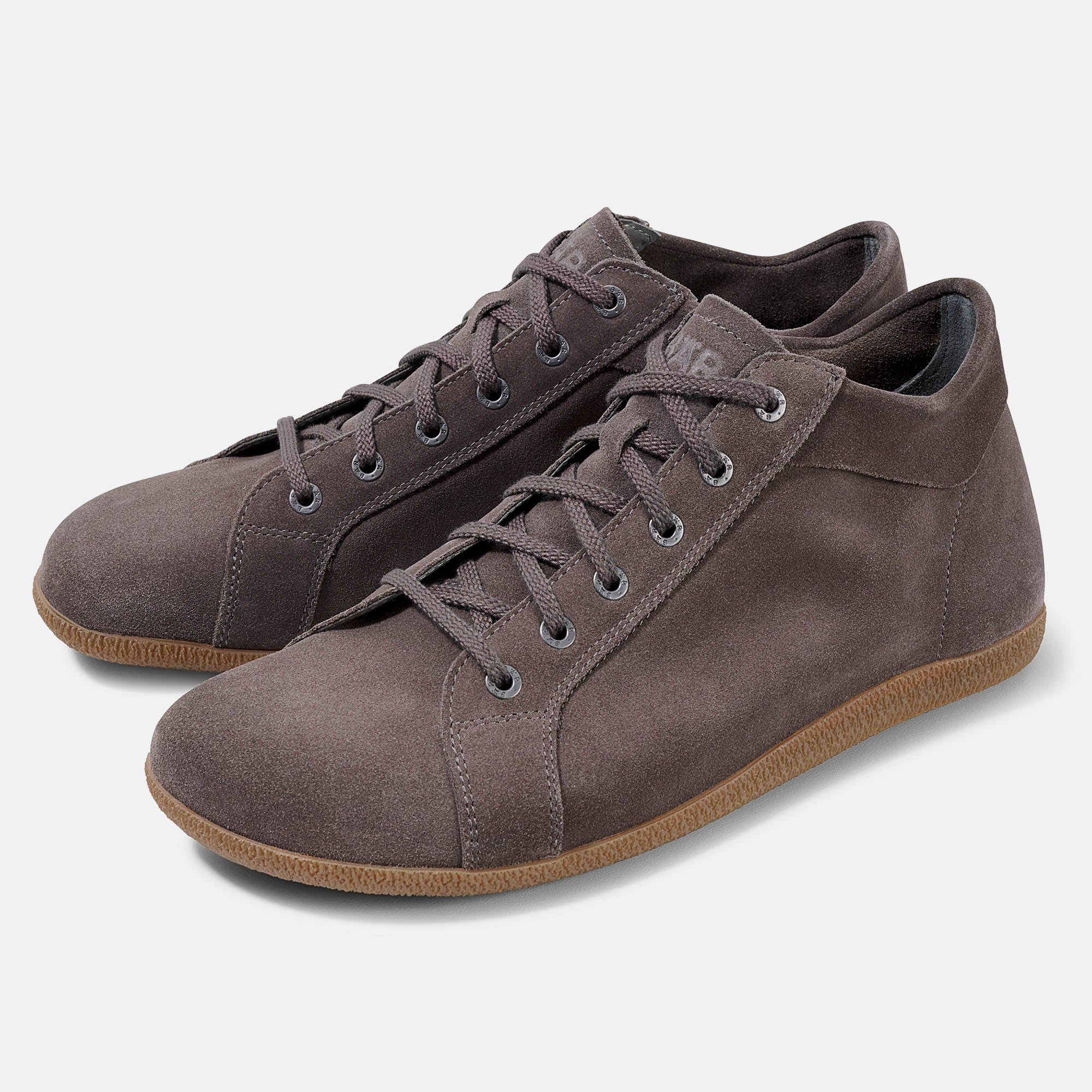 Zwei braune Stiefeletten mit Schnürsenkeln. Obermaterial aus Wildleder, helle Sohle. Seitliche Ansicht.