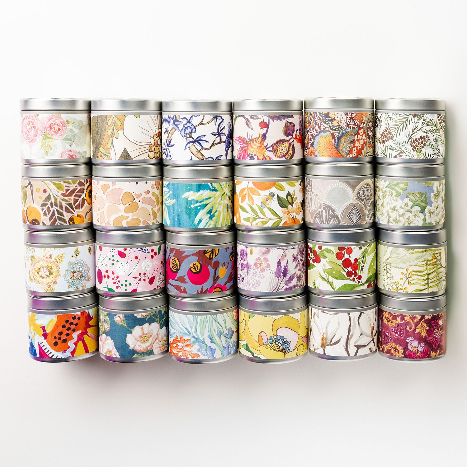 Reihe von Kerzen in Dosen mit floralen und abstrakten Mustern.