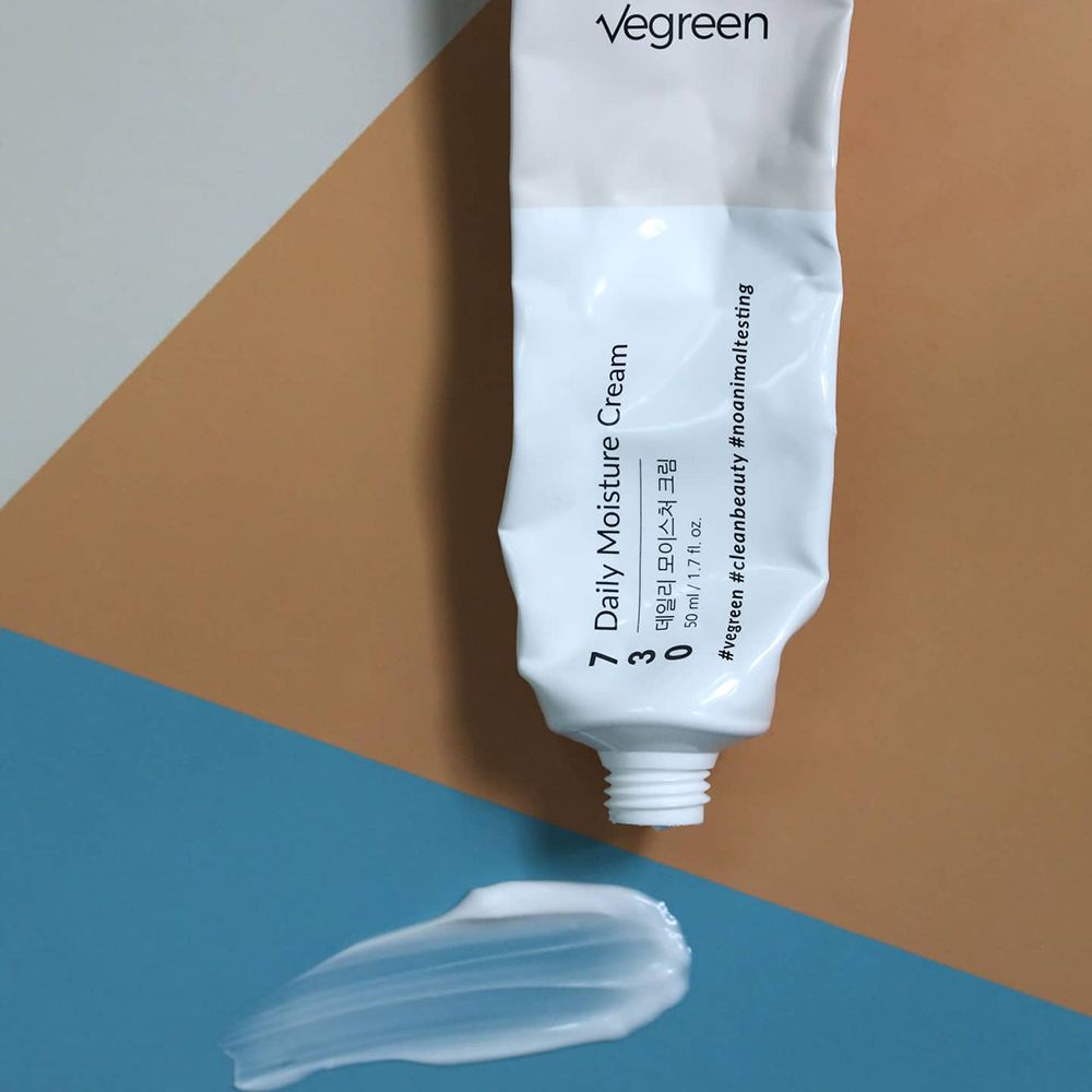 Ausgequetschte Creme aus Tube. Produktname und Text auf der Tube. Creme auf farbigem Hintergrund.
