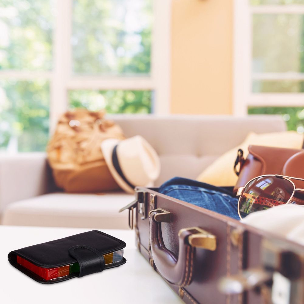 Schwarzes Etui in einem Koffer. Koffer mit Kleidung und Accessoires. Tablettenbox sichtbar.