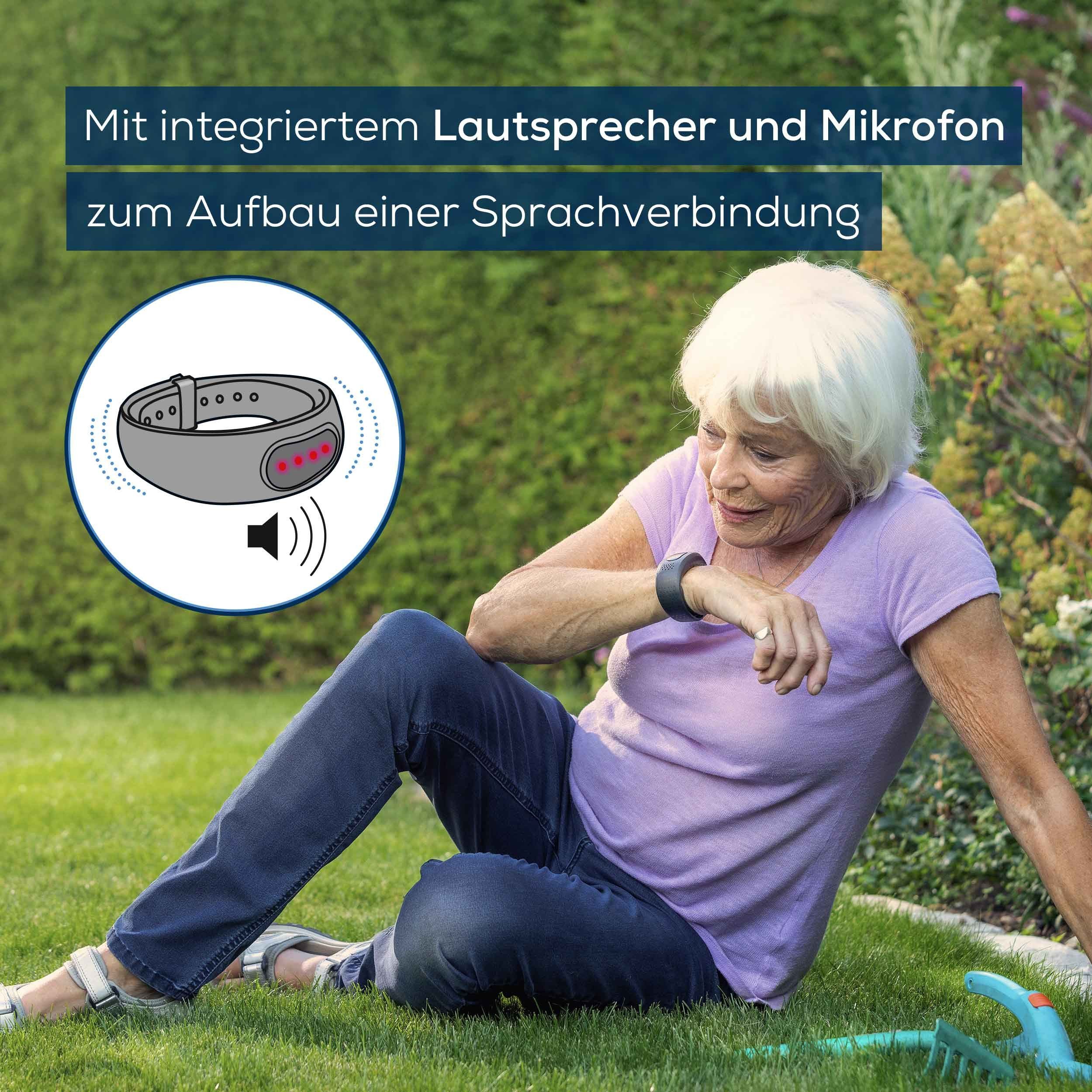 Ältere Frau sitzt im Garten mit Notrufarmband. Text: Mit integriertem Lautsprecher und Mikrofon zur Sprachverbindung.