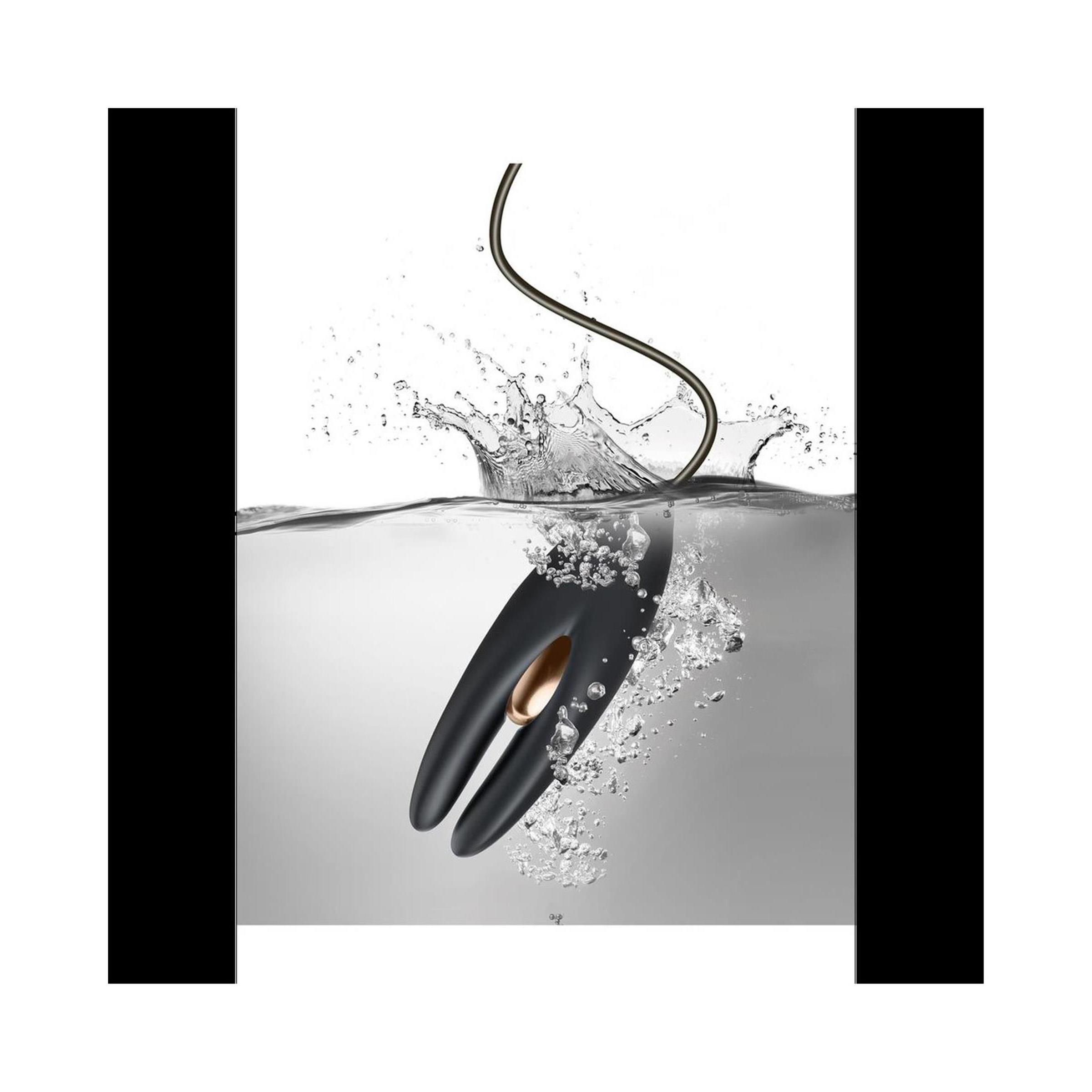 Schwarzes Produkt im Wasser. Goldfarbenes Element. Wasserspritzer.