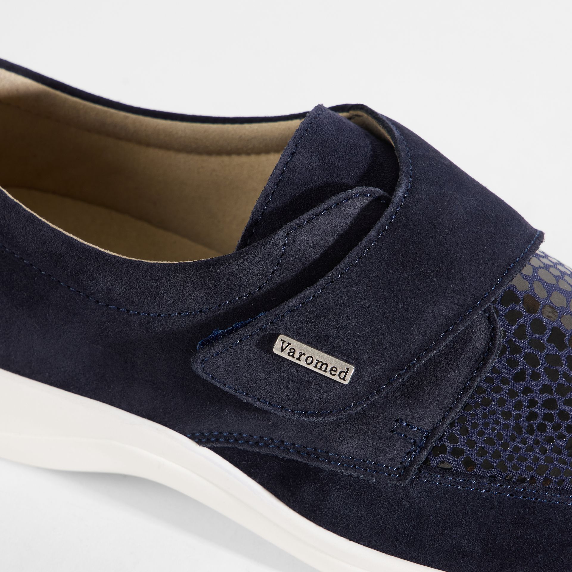 Dunkelblaue Damenschuhe mit Klettverschluss und weißer Sohle.